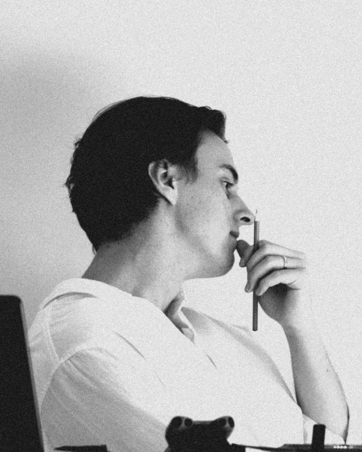 James, co-founder of Solé, in profile holding a pencil, black and white portrait
